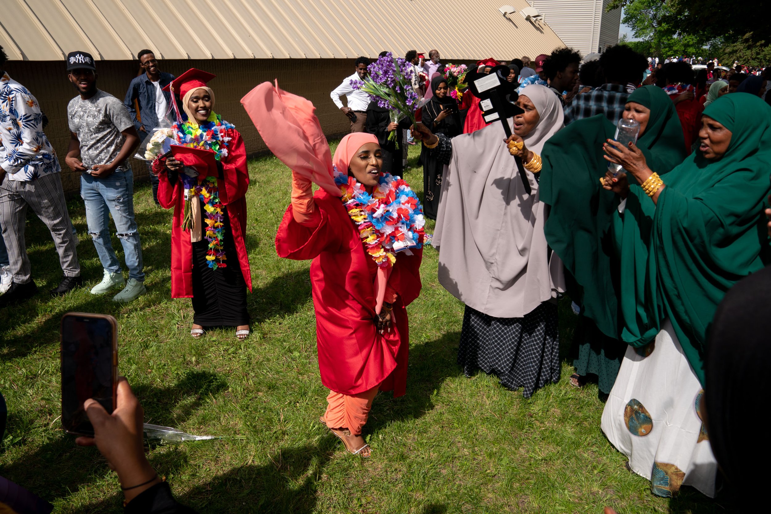  2022 Graduate Faiza Abdulahi, 18, dances to a beating drum as family and friends celebrate with her after the commencement ceremony at Willmar Senior High School in Willmar, Minn. 