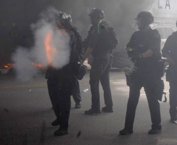  A LAPD officer fires a less lethal projectile at News photographer Nick Stern 