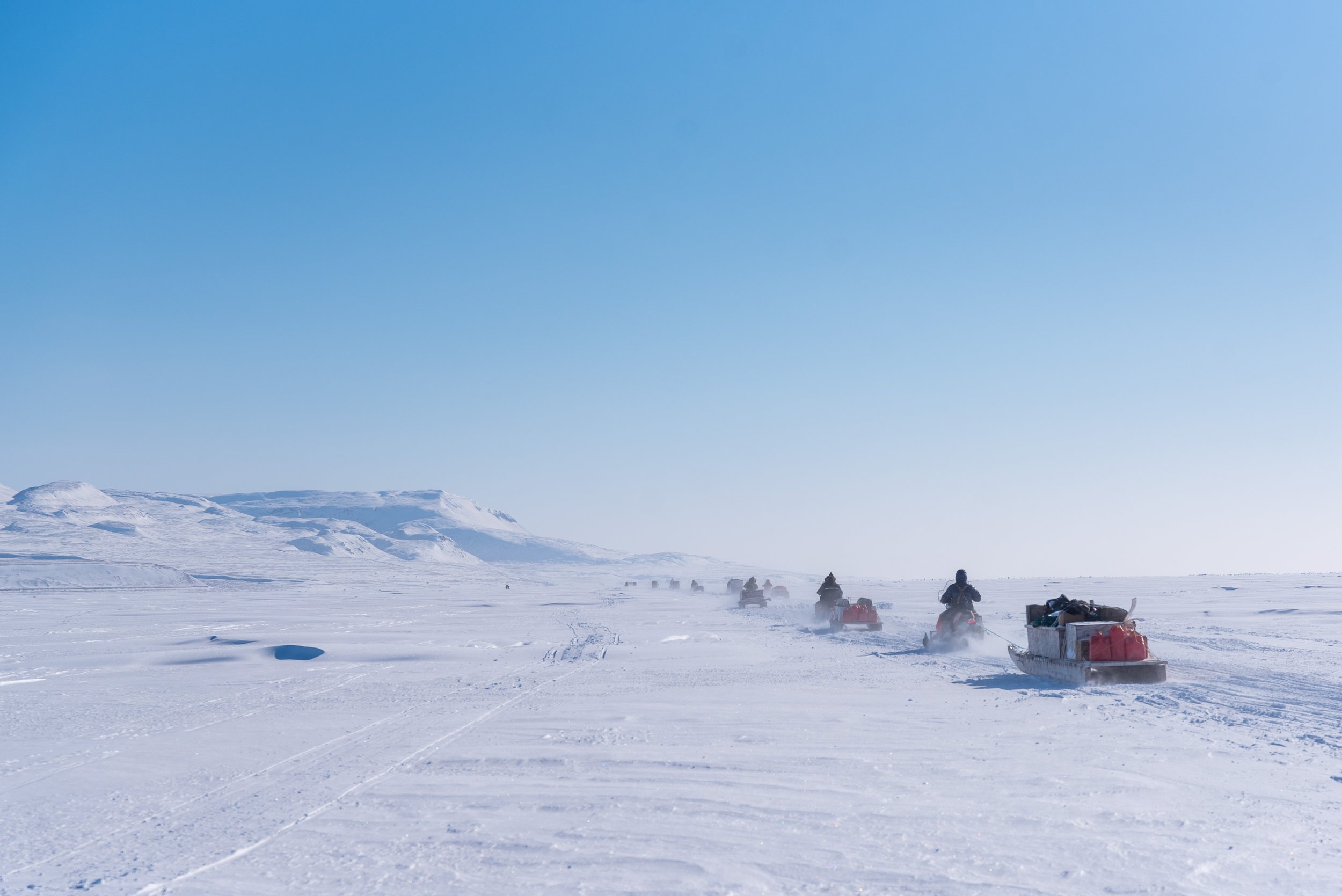  A convoy of support snowmobiles with qamutiik in tow head toward the first Nunavut Quest camp, roughly 50km outside of Arctic Bay, Nunavut on Monday, April 18, 2022. Taken for The Canadian Press 
