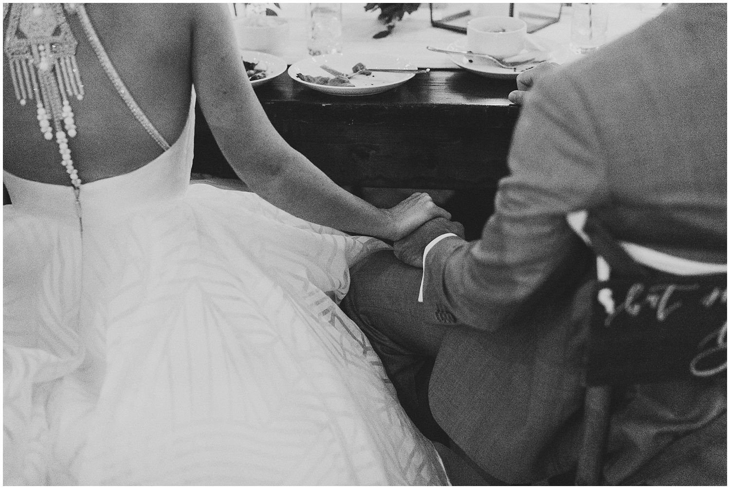 bride and groom holding hands during dinner