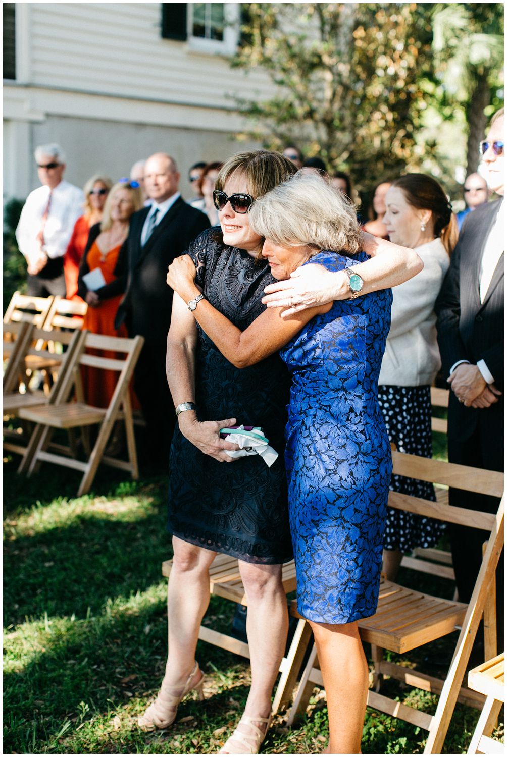 Mom hugging stepmom at wedding