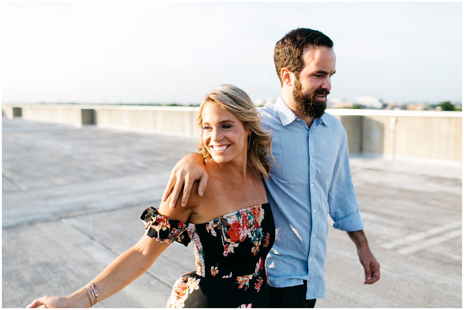 Couple walking on rooftop during engagement session