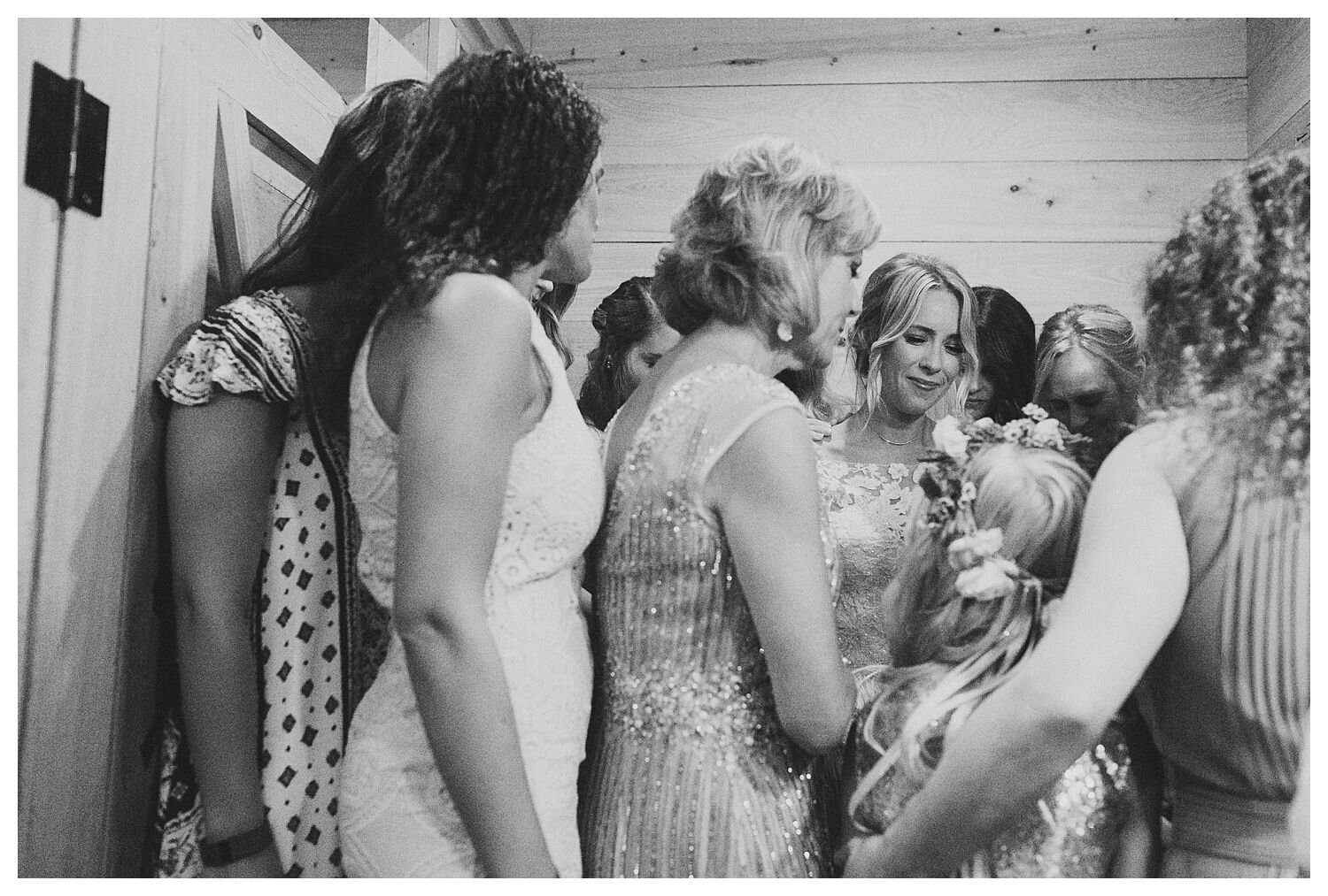 bridesmaids praying over bride