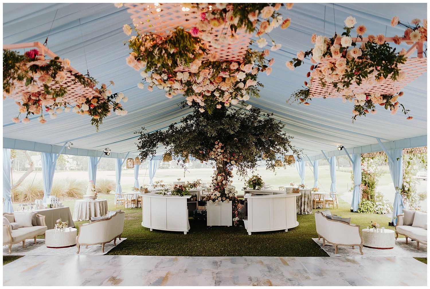 floral installation inside blue draped wedding reception tent