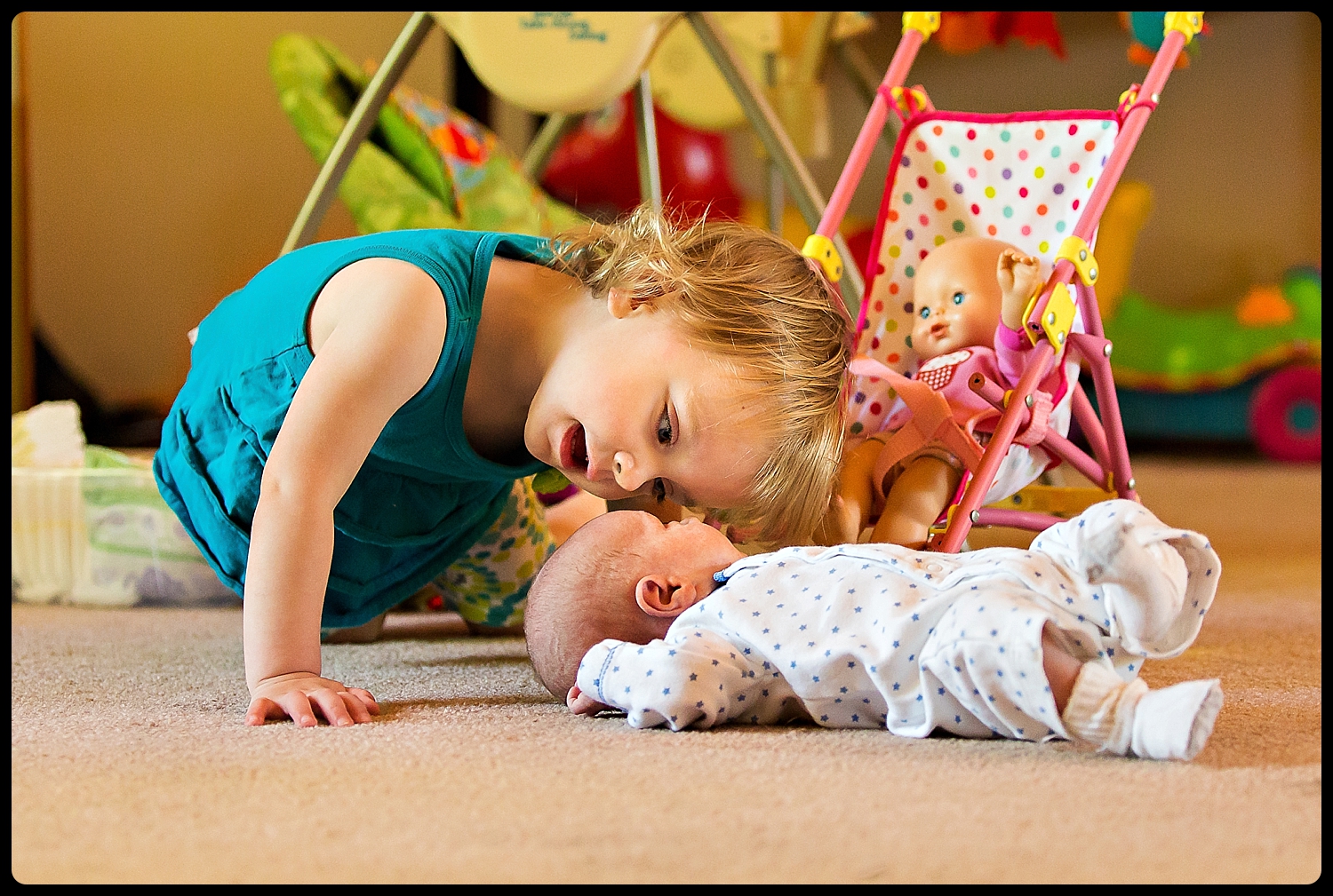 Little girl looks at her baby sibling like a doll.