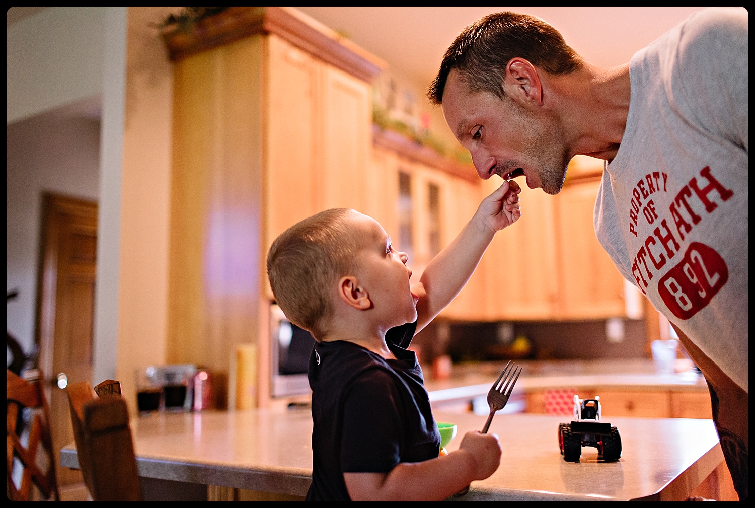 Little boy feeding his father grapes.