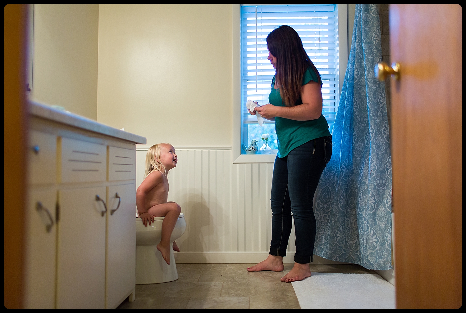 Mother encourages daughter while potty training.