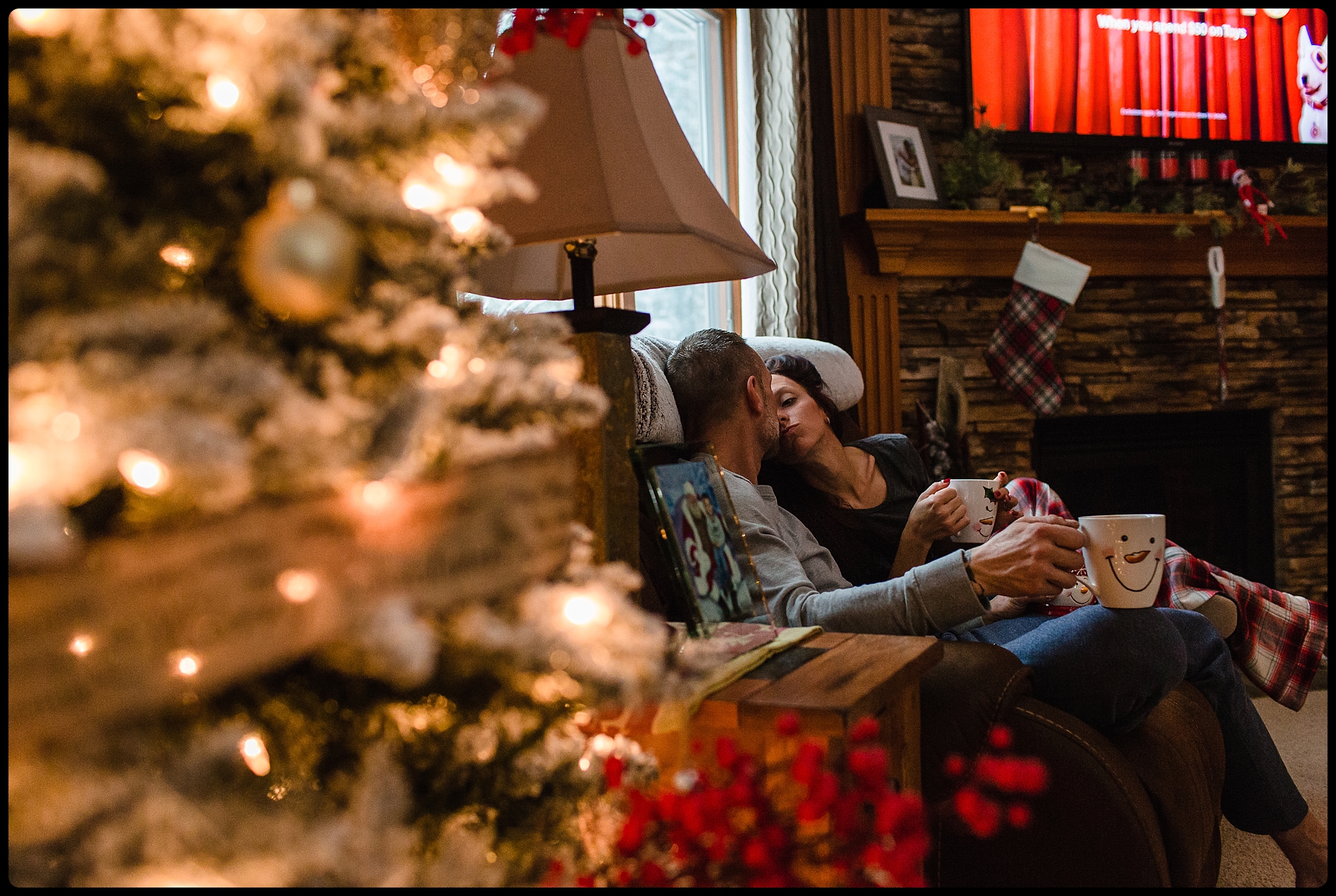 Couple shares a kiss over hot cocoa at Christmas time.