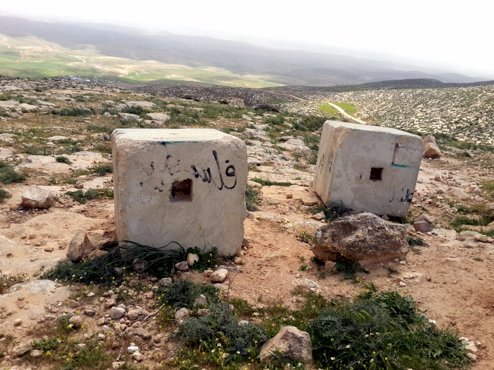Concrete blocks placed by the military on the western access road to the Masafer Yatta area. The houses of Khirbet Jenbah are seen at the bottom of the valley. Photo by Osnat Skoblinski for B'Tselem.