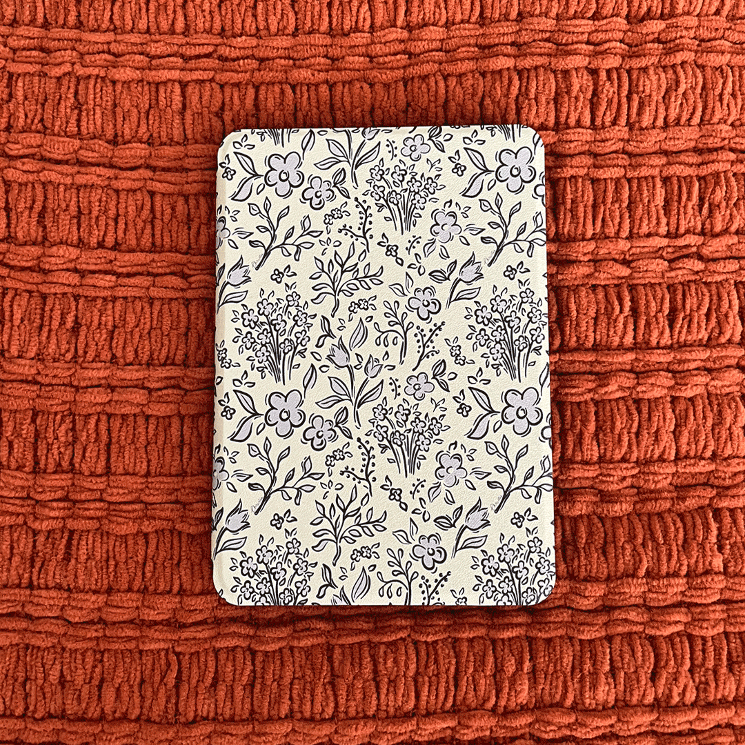 Animated gif of custom kindle case with light blue and navy floral design, on orange background