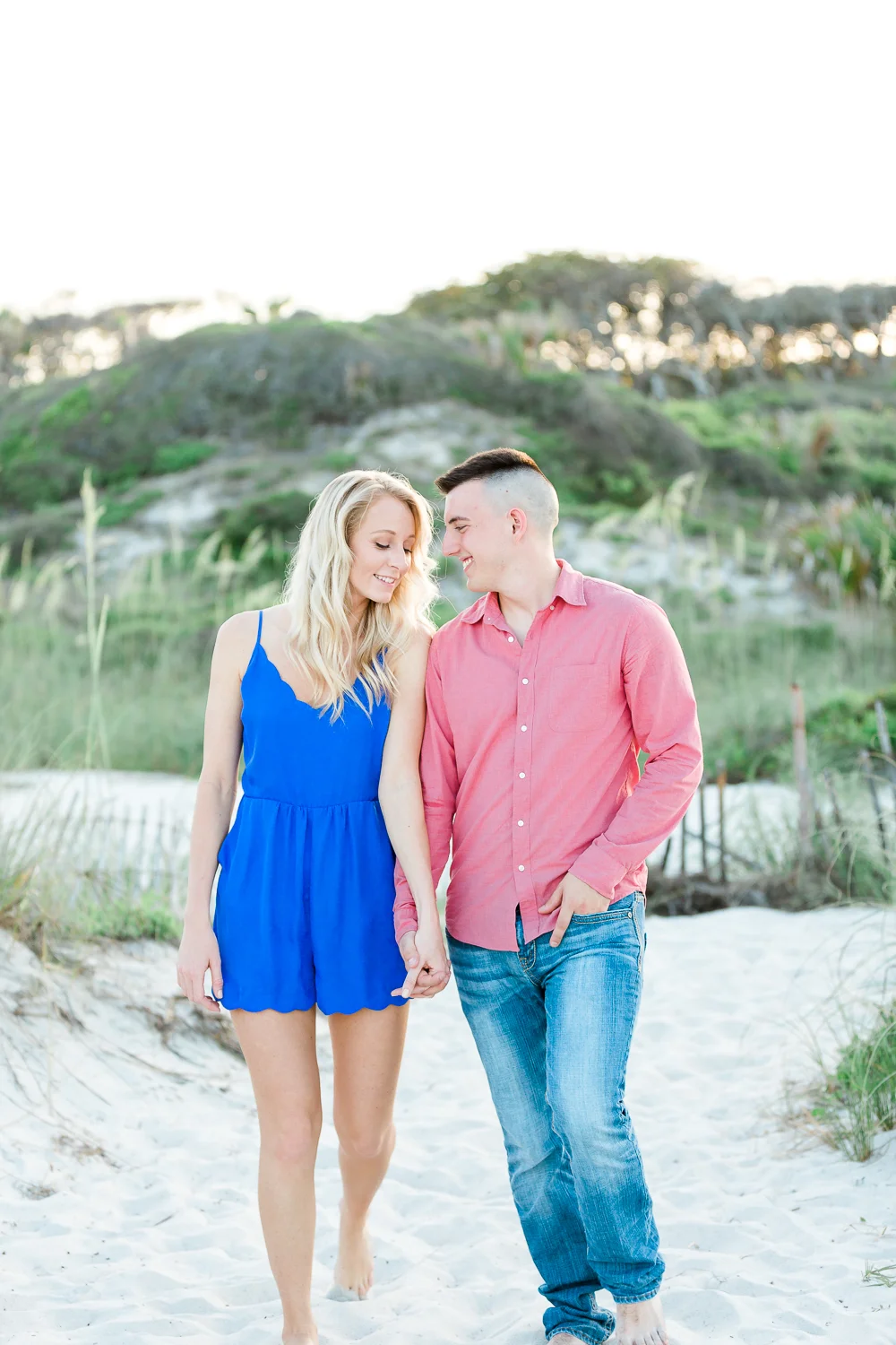 engaged couple walking at the beach.jpg