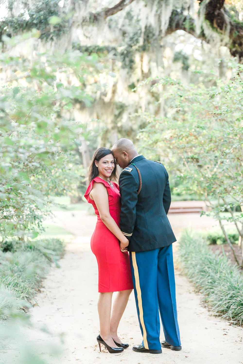 couple holding hands under spanish moss