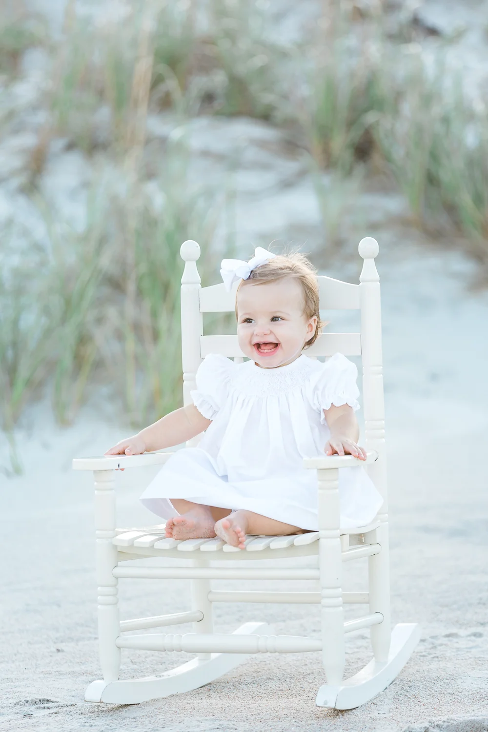 baby girl in a rocking chair at the beach