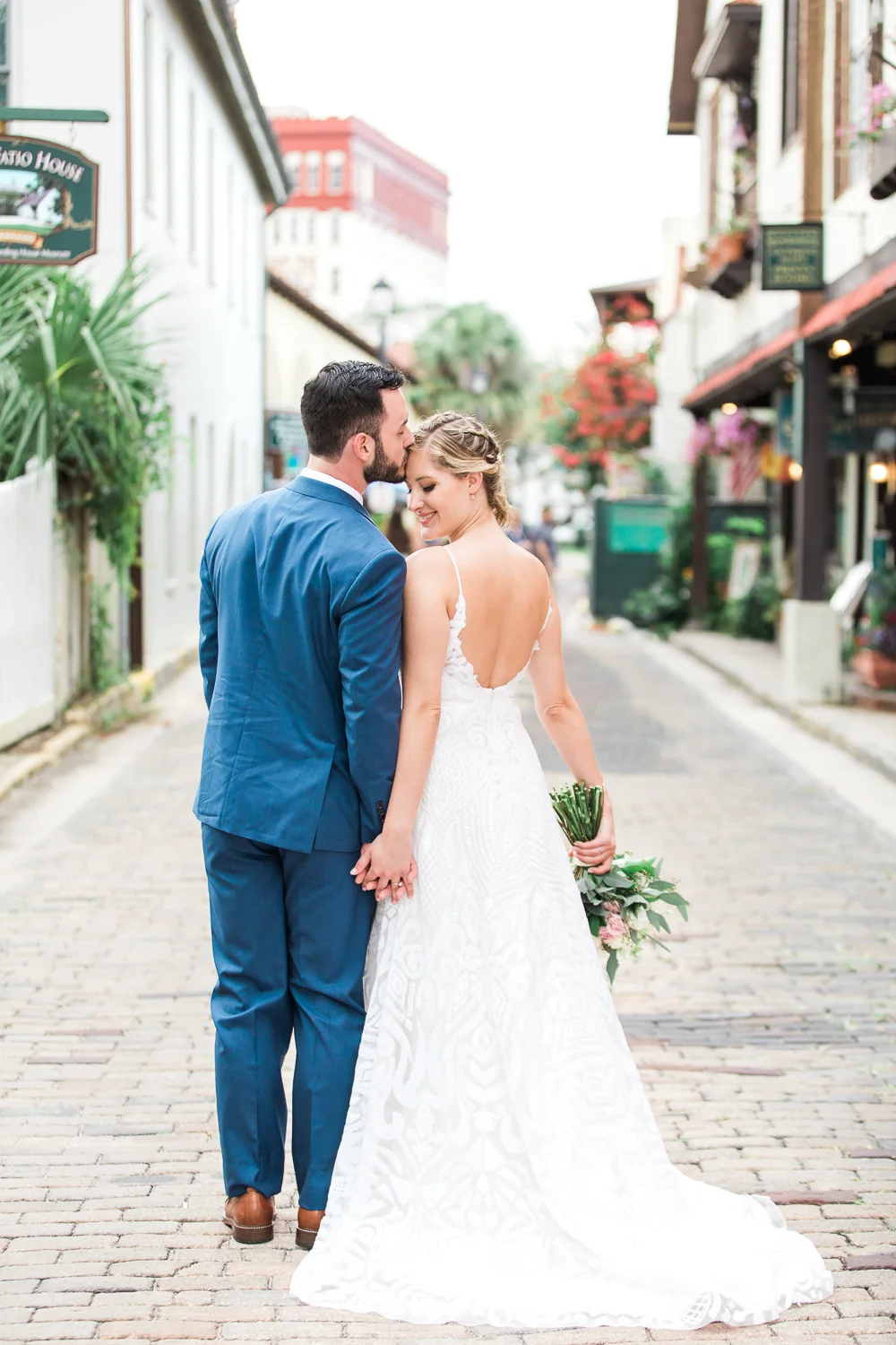 Groom kissing the bride in the forehead