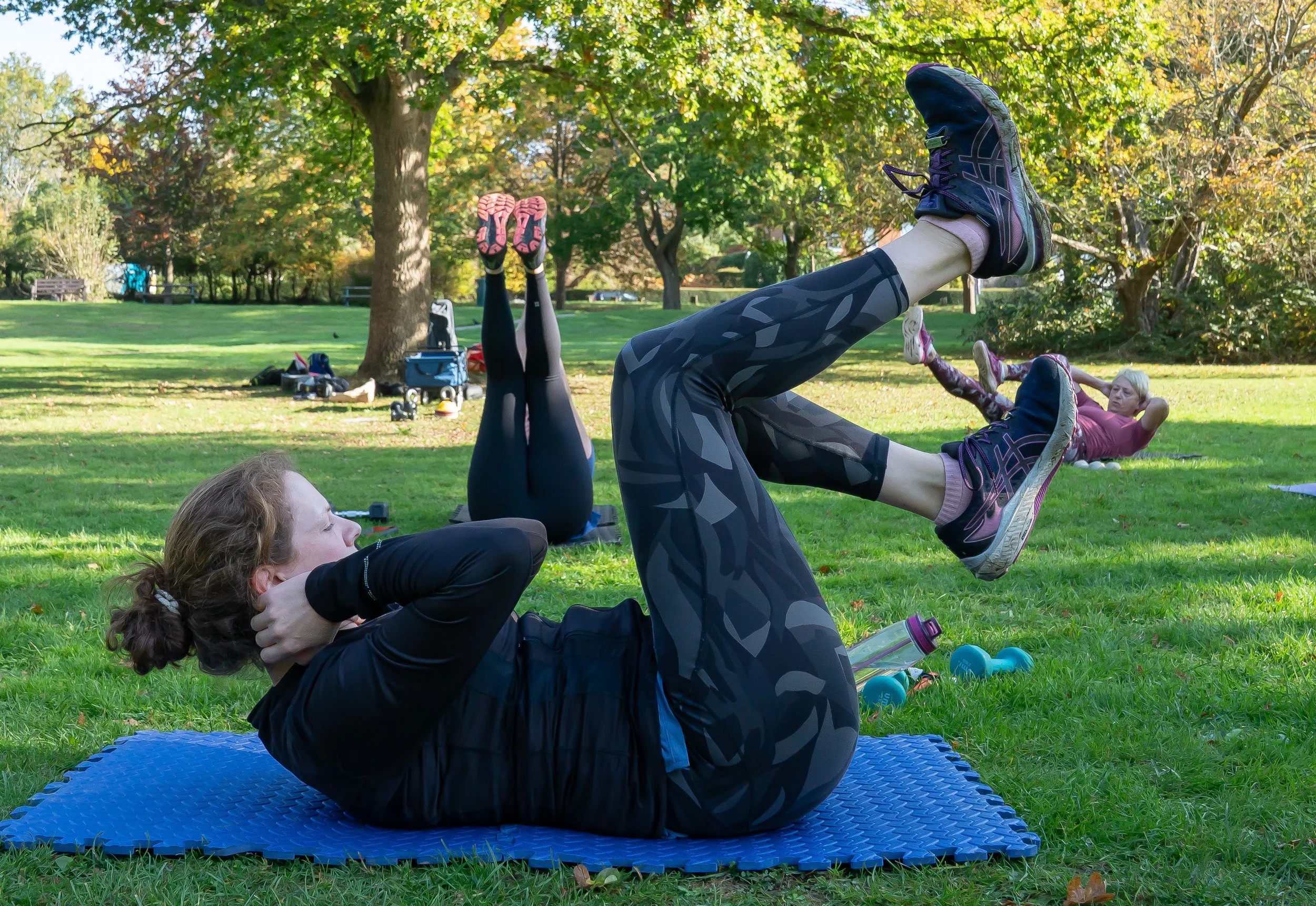 A lady in a park doing abs exercises