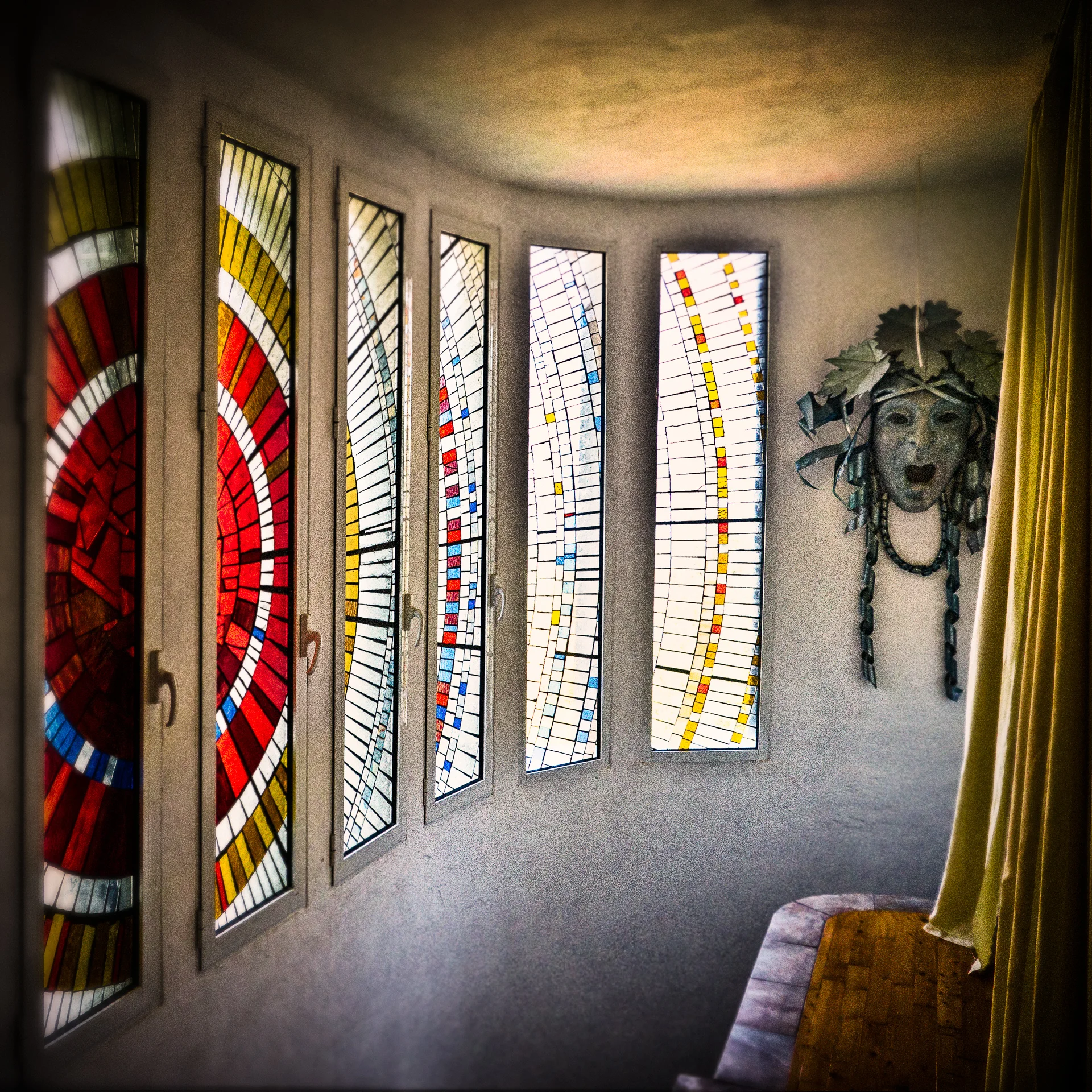 The coloured glass windows were achieved very simply. The technique is not unlike applying ceramic tiles. The coloured glass shapes are applied to a sheet of plate glass, cut to the size of the window frame, using clear silicone adhesive. The gaps are then filled with a mixture of black grout and PVA. The window frames were the only parts of the structure which we didn’t contrive ourselves, though we have had help of all kinds from friends and family.