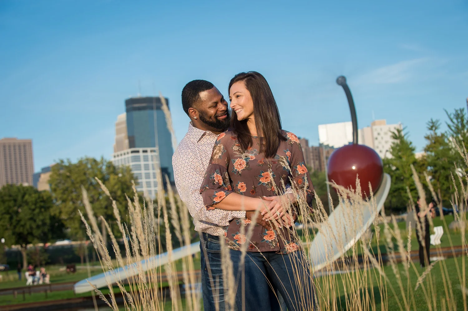 A couple poses for pictures near the Spoon and Cherry Bridge at the Minneapolis Sculpture Garden.