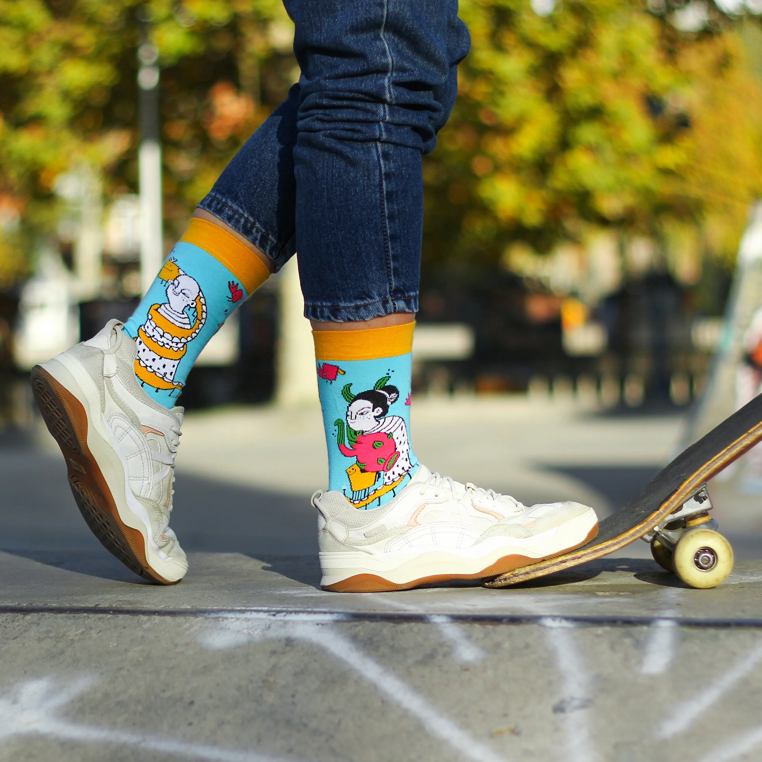 Pair of Masholand designed socks from AlterSocks limited artist collection, featuring whimsical illustrated characters.