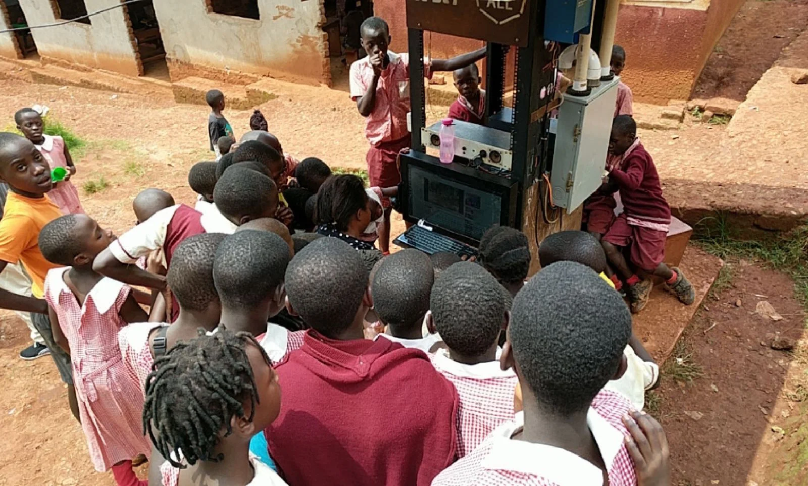 Students of St. James Primary School, Uganda, work with their teacher at the Hello Hub. 