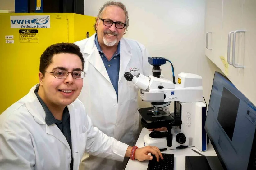 Sina Kiamehr, a senior at Francisco Bravo Medical Magnet High School, works with Daryl Davies of the USC School of Pharmacy. (USC Photo/Gus Ruelas)