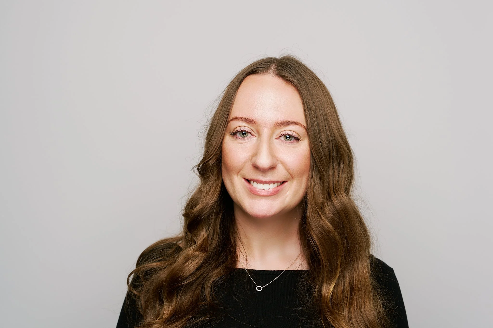 Modern professional headshot photographed on location using studio lighting and a light grey background