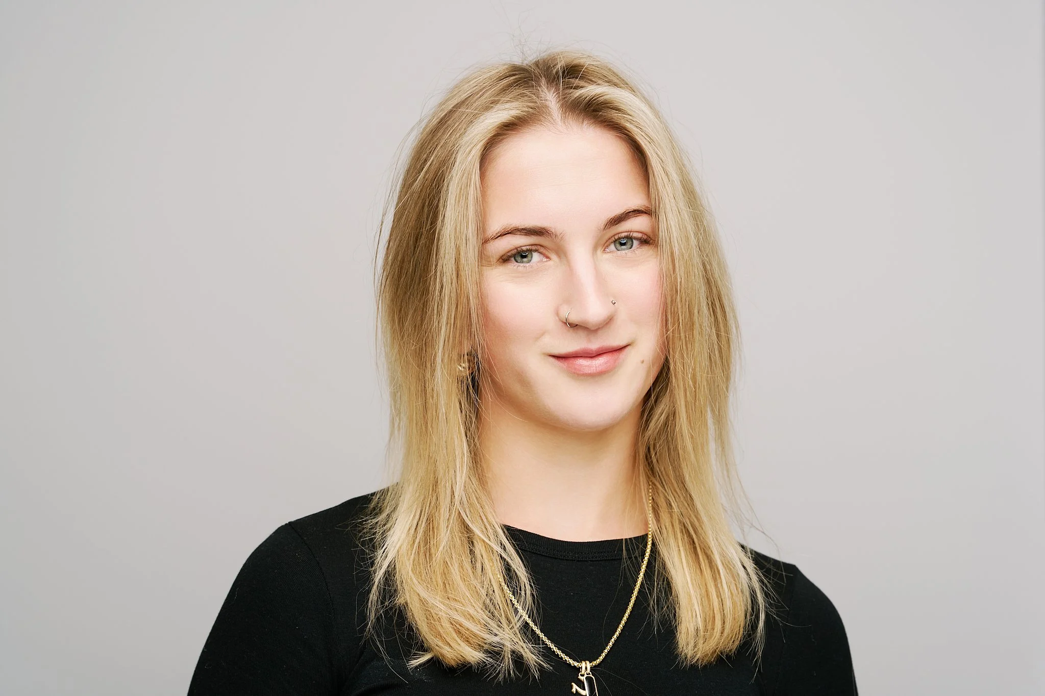 Professional on-location headshot of a business professional photographed against a light grey studio-style background