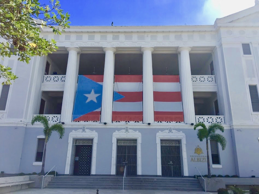 The Puerto Rican flag displayed on a university building off a plaza in Old San Juan.