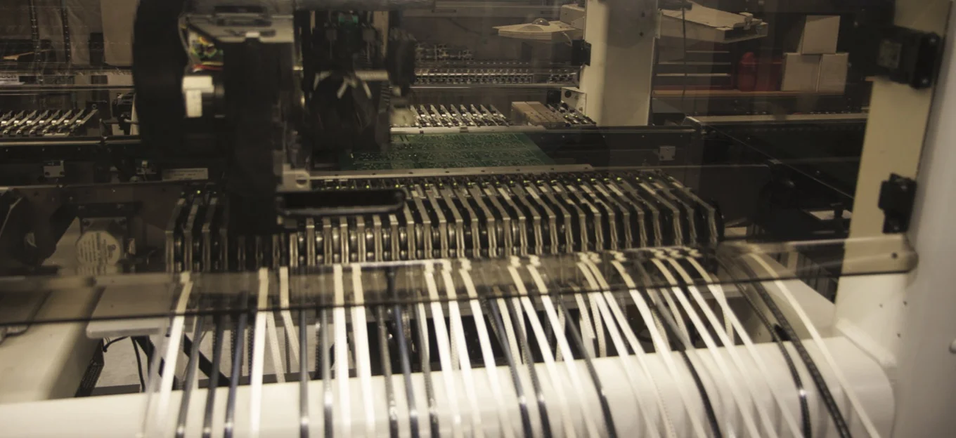 Electronic components are handled by a robot that is programmed to build each distinct board for every NK product.