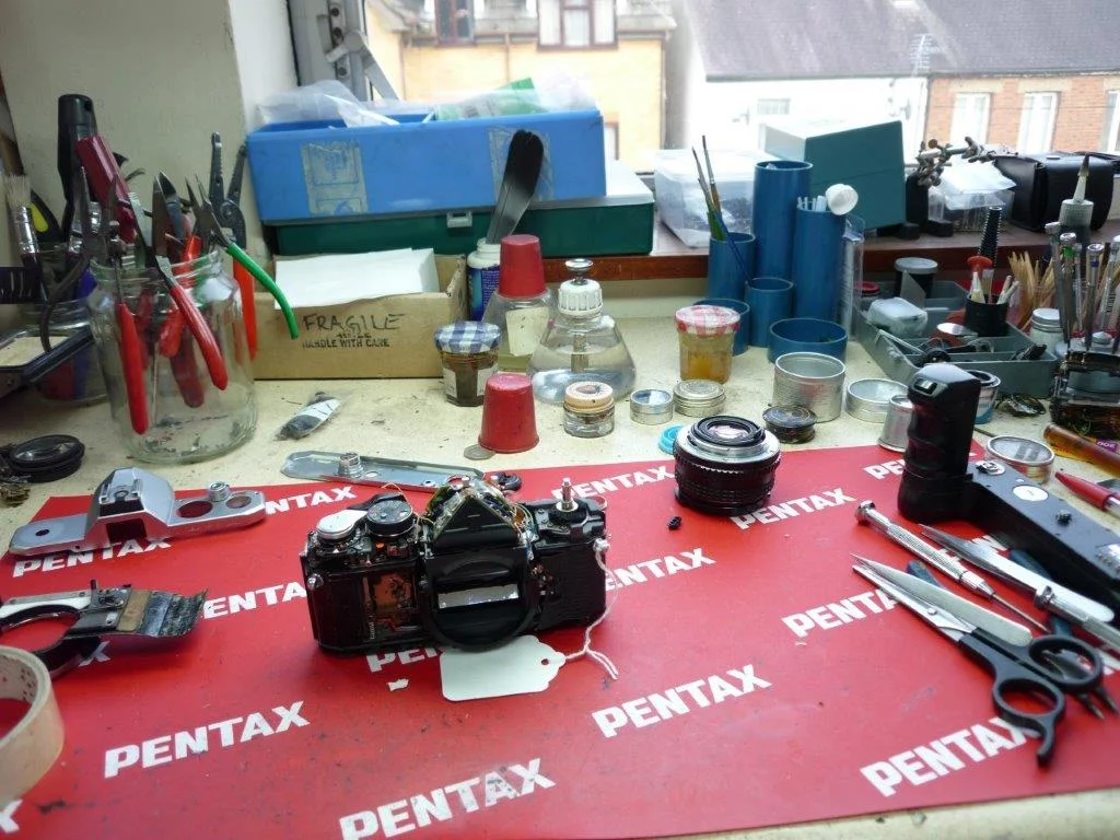 A wider view of the work bench, since Robin took the trouble to photograph it. The same MX in déshabillé, fumbling hastily for its bottom plate. Looks like some Bonne Maman jam jars back there, probably full of specialty greases and oils. Let's hope Robin doesn't get his marmalade mixed up with his Nye 140C! 