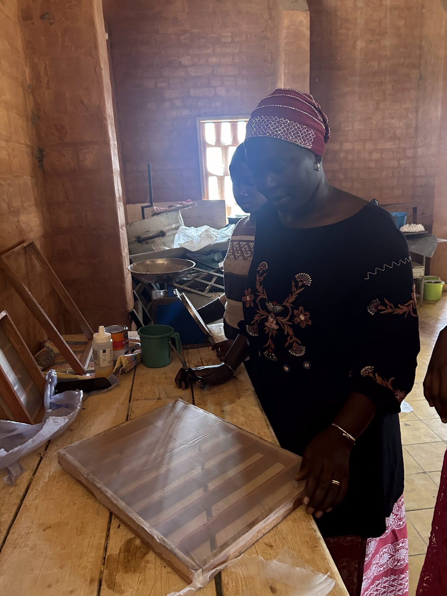 Fatou tenant le moule à papier dans l'atelier