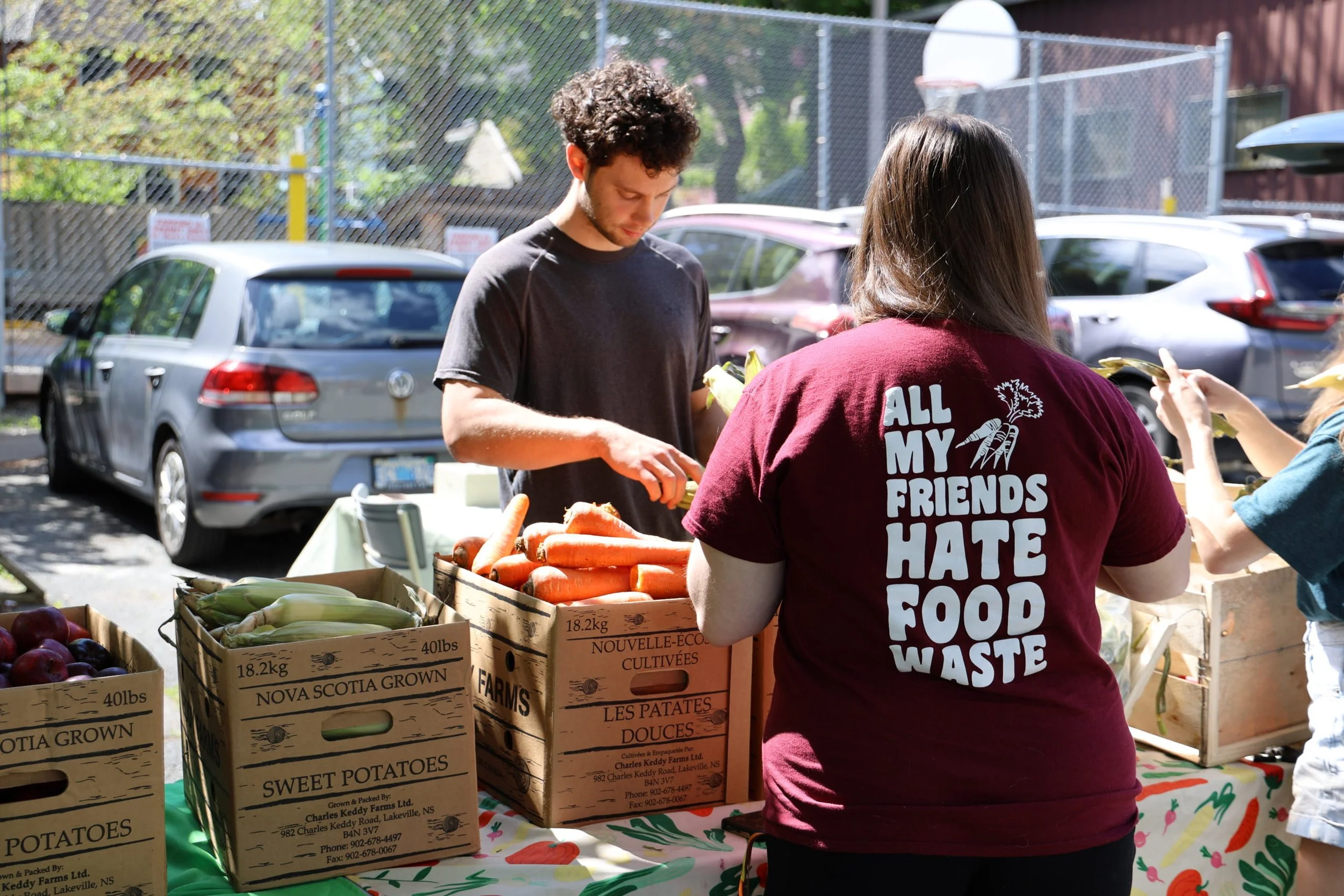 Students work at a table with boxes of produce