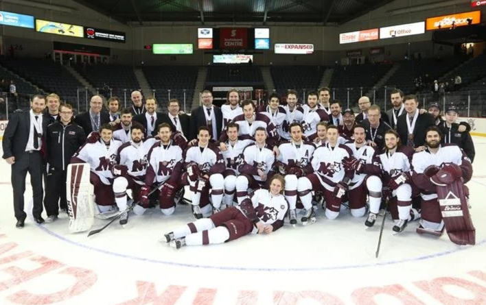 Men's hockey team poses on ice