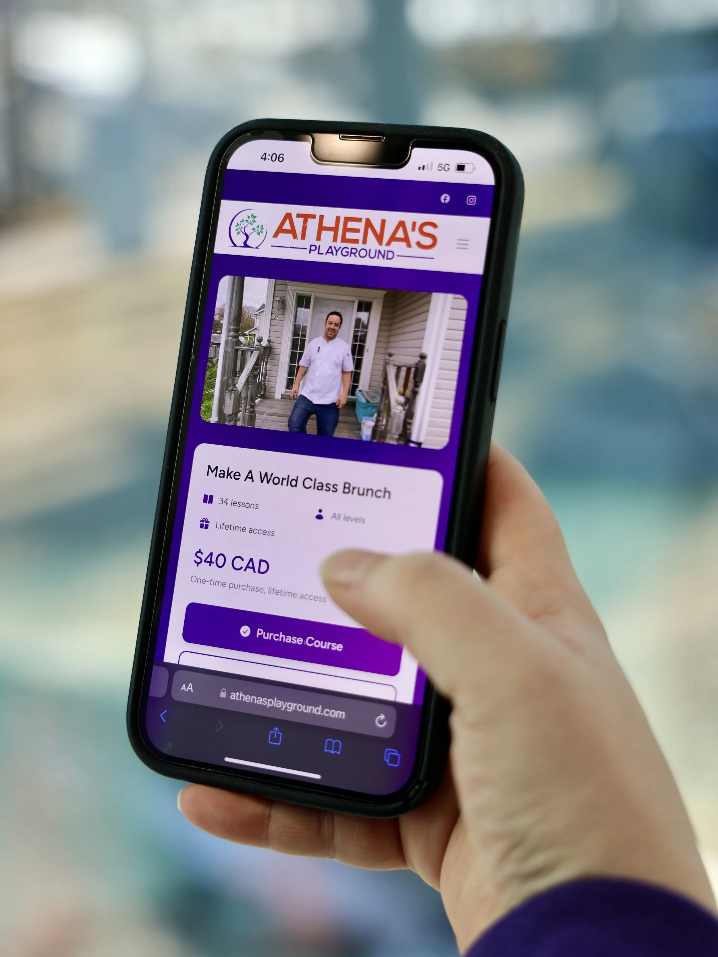 A hand holds a phone with the business website showing an available course