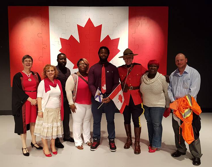 Stephen Robinson-Enebeli (centre right) stands with family members and citizenship ceremony officiants.