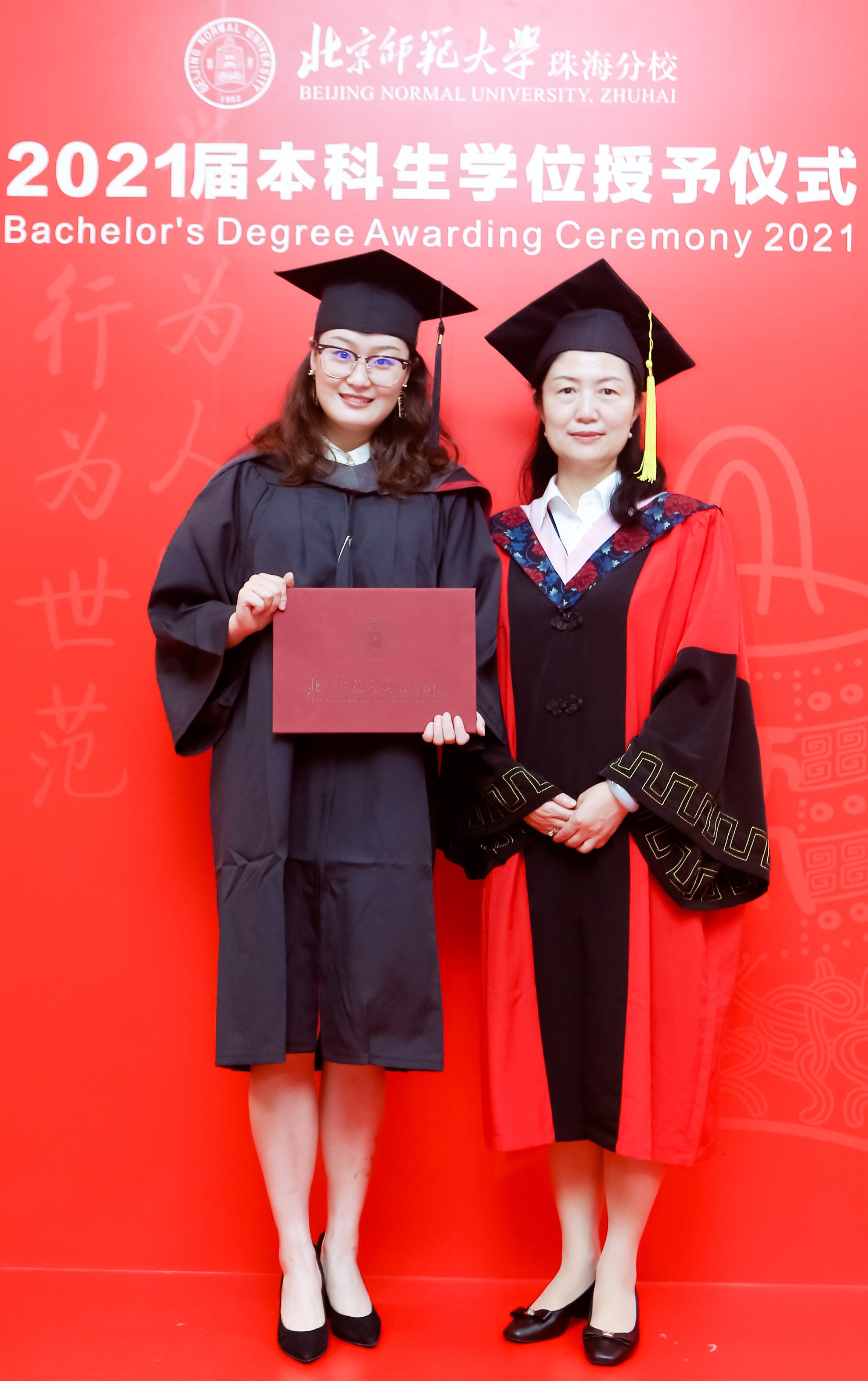   Prof. Zhong Xin, Dean of the International Business Faculty at BNUZ presents Lu Jingyi with her degree during the IBF degree awarding ceremony. In total, 63 students graduated from the BNUZ-SMU Joint BComm Program on June 26th.  