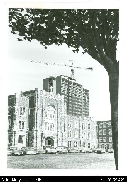  Springtime photograph of McNally Building and a nearly-finished Loyola residence in the background, taken from Robie Street facing southeast. 