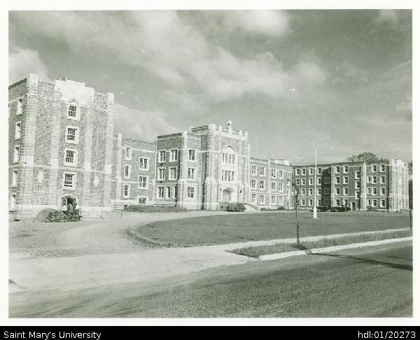  Photograph of newly built McNally Building in springtime, looking southeast from Robie Street. The driveway is still dusty from wheels of construction vehicles, and no trees have been planted yet except for one tiny specimen at the curb. At left thr