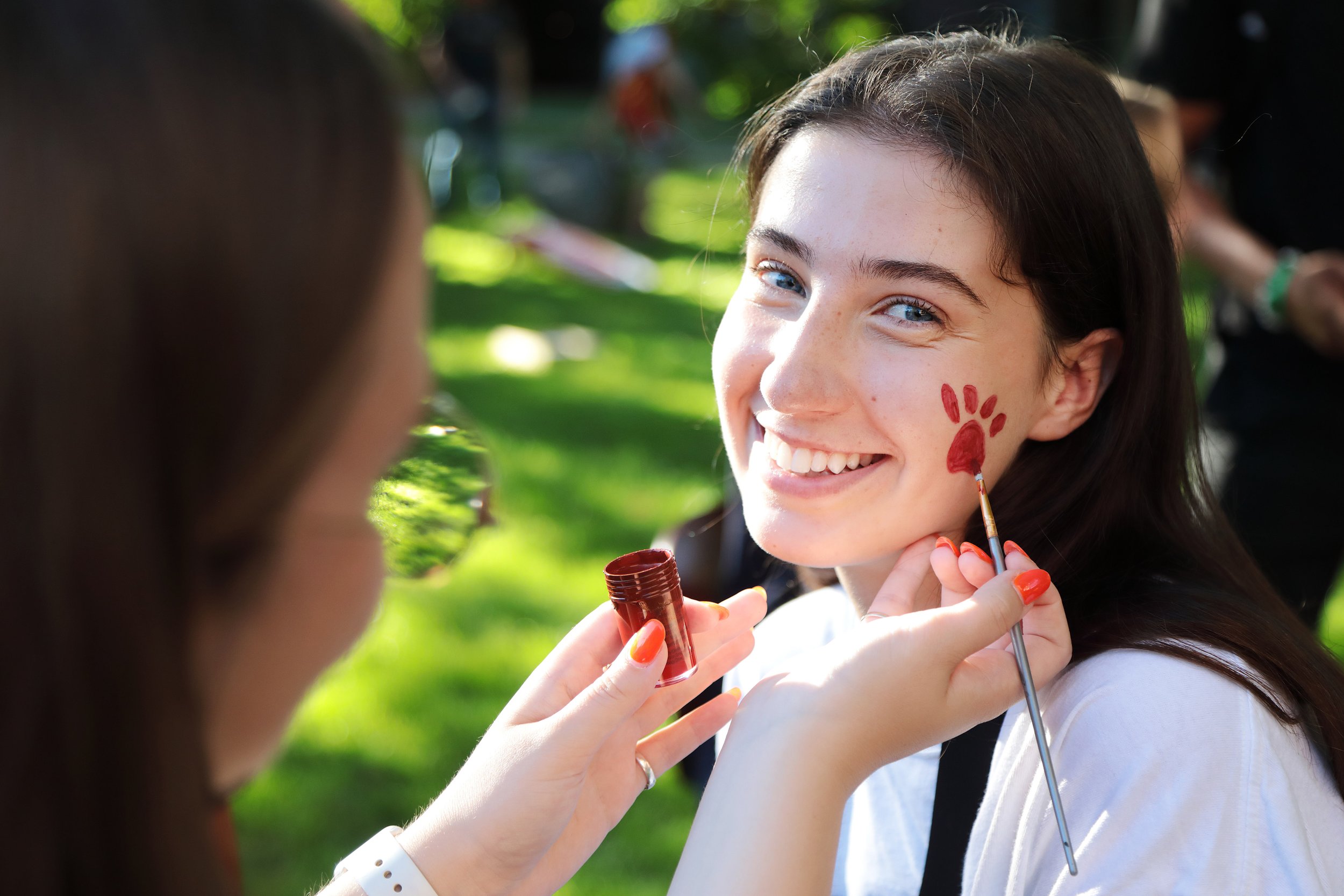 Student getting a husky paw print face painted