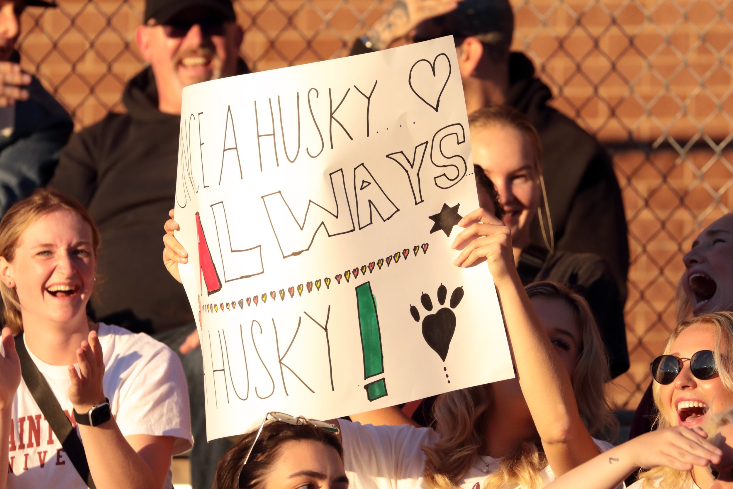 Fans in the crowd with a sign supporting the huskies
