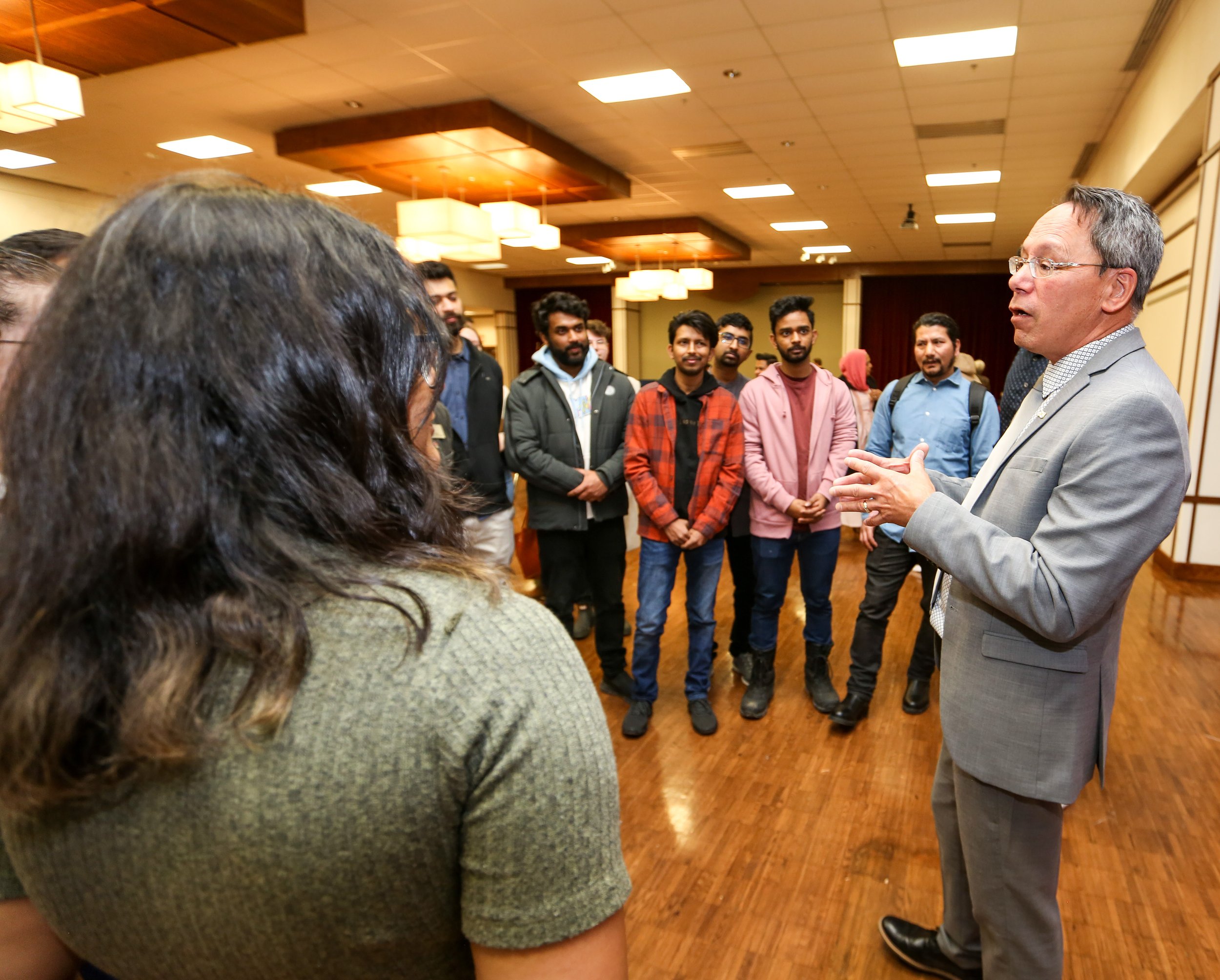  Brian Wong talking to students and others at the funding announcement event. 