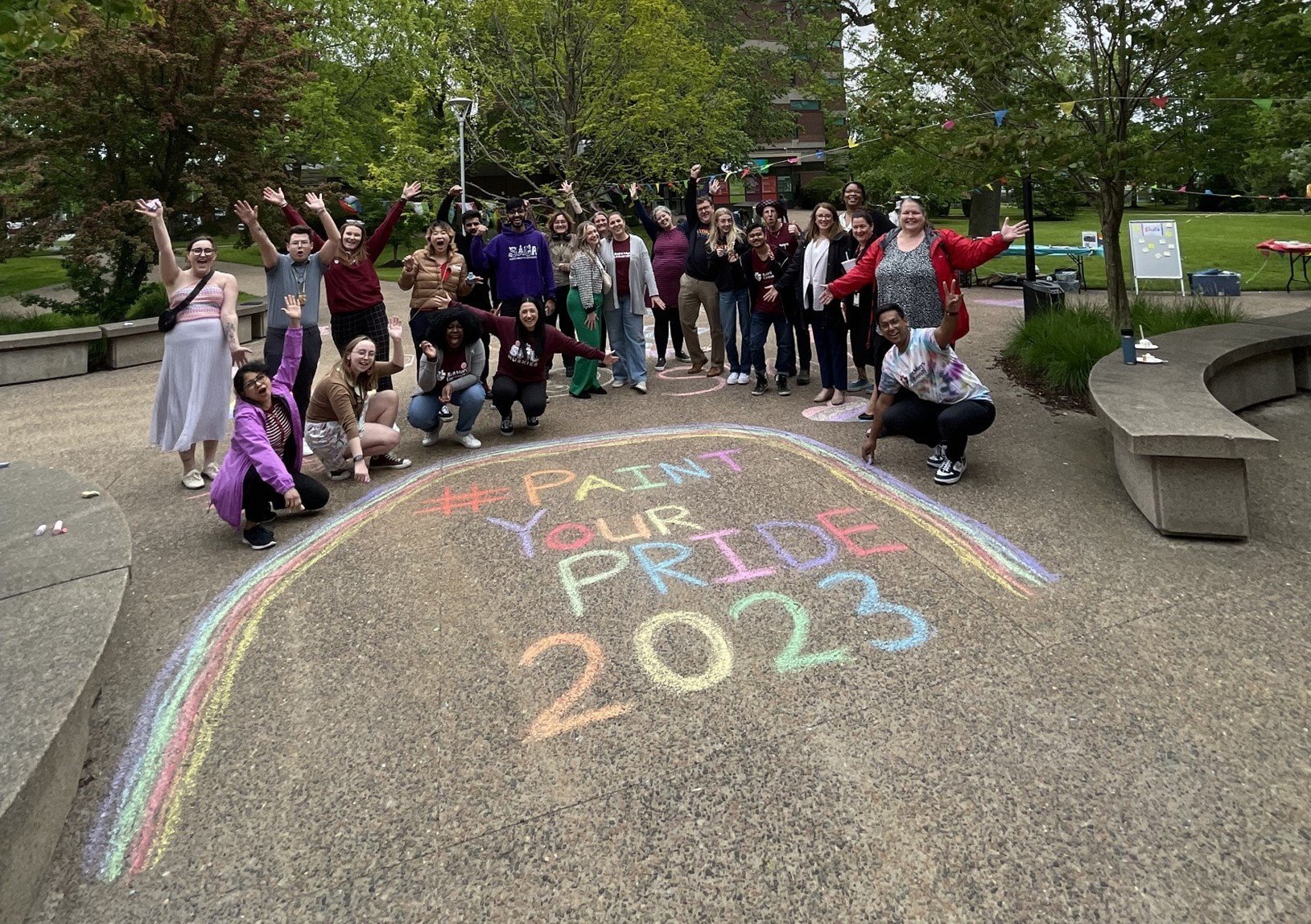  Group of people standing in Saint Mary's University Quad in front of colourful chalk rainbow and chalk sign reading Paint Your Pride 2023 