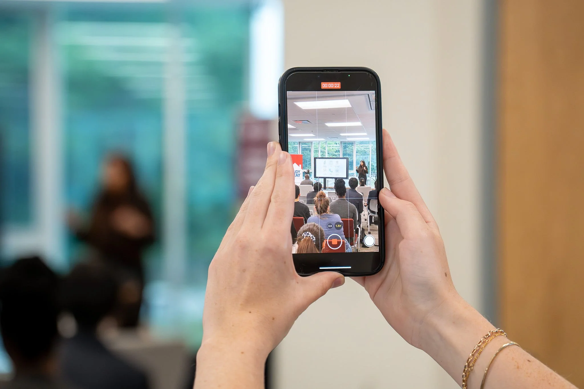 Person recording one of the presentations on their phone.jpg