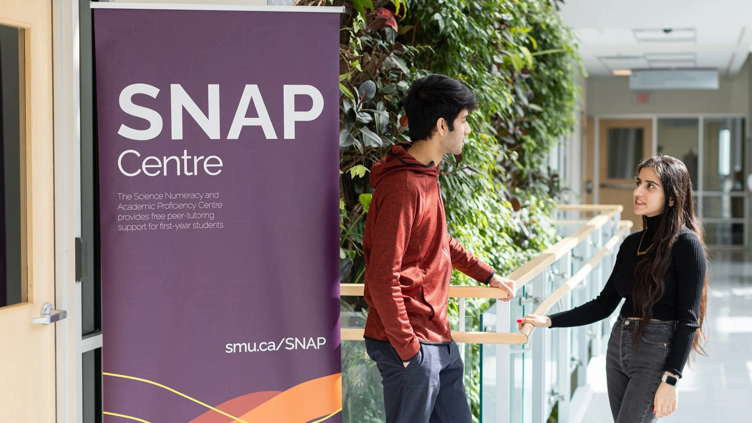Two students stands outside the SNAP centre on campus