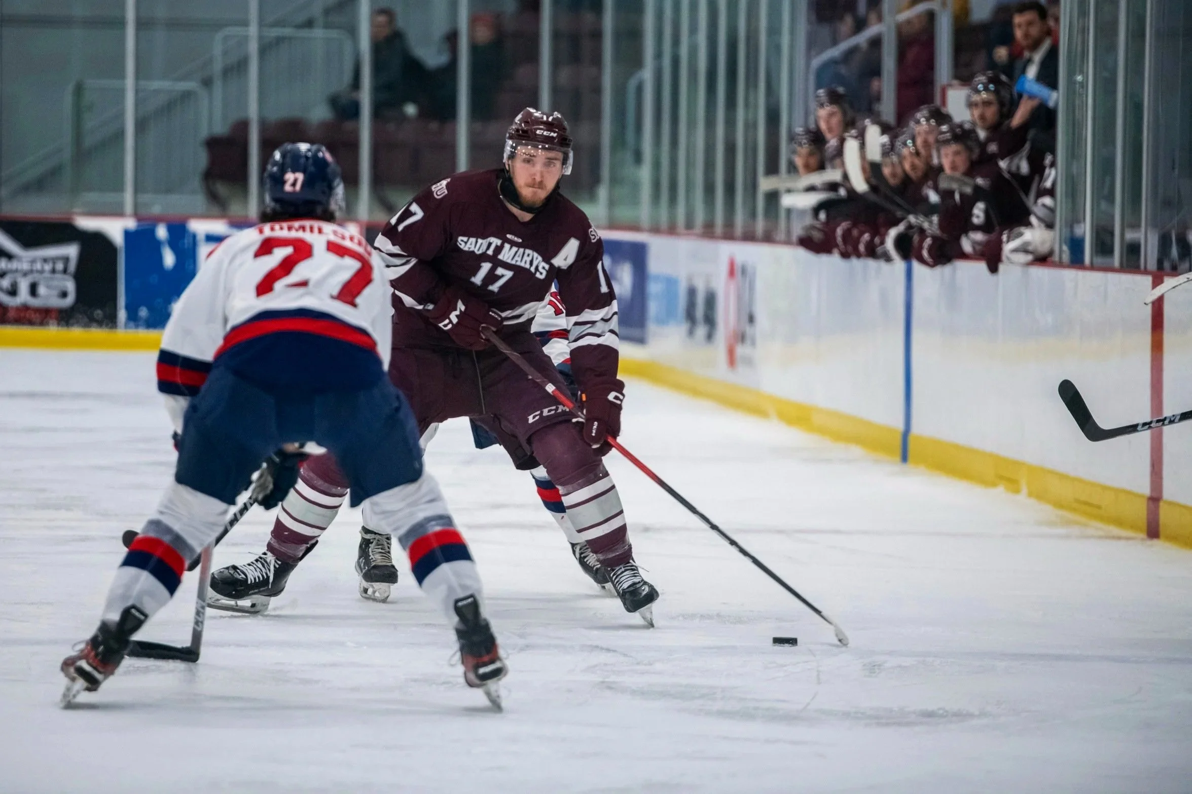 A Huskies player faces off against a another player while his team looks on