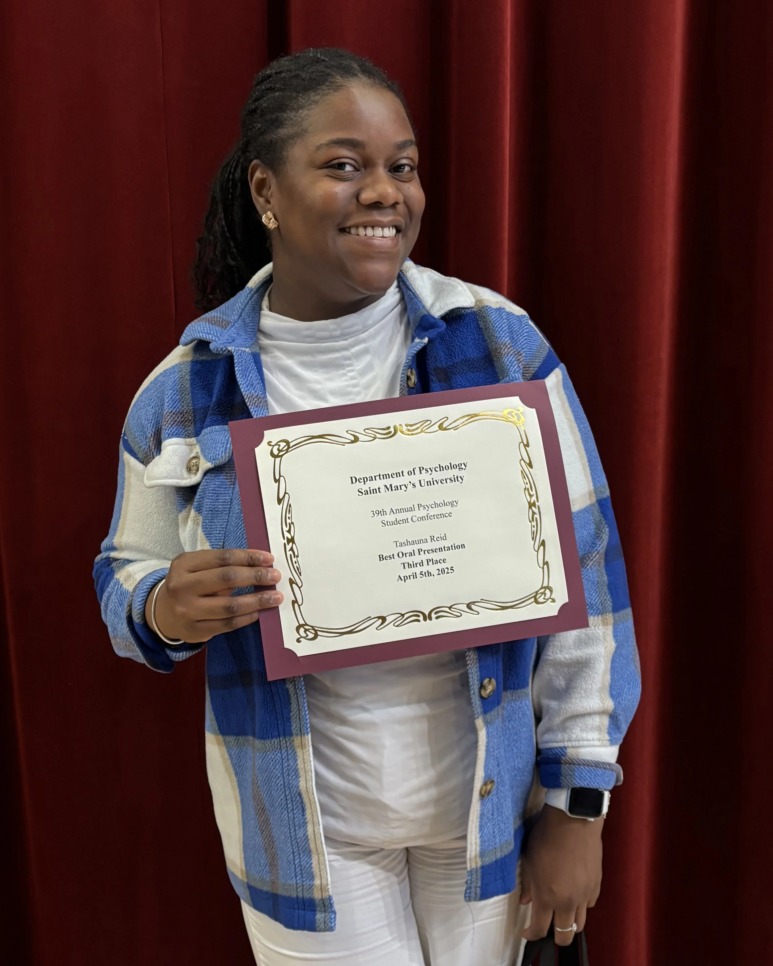 Tashauna holding her award certificate