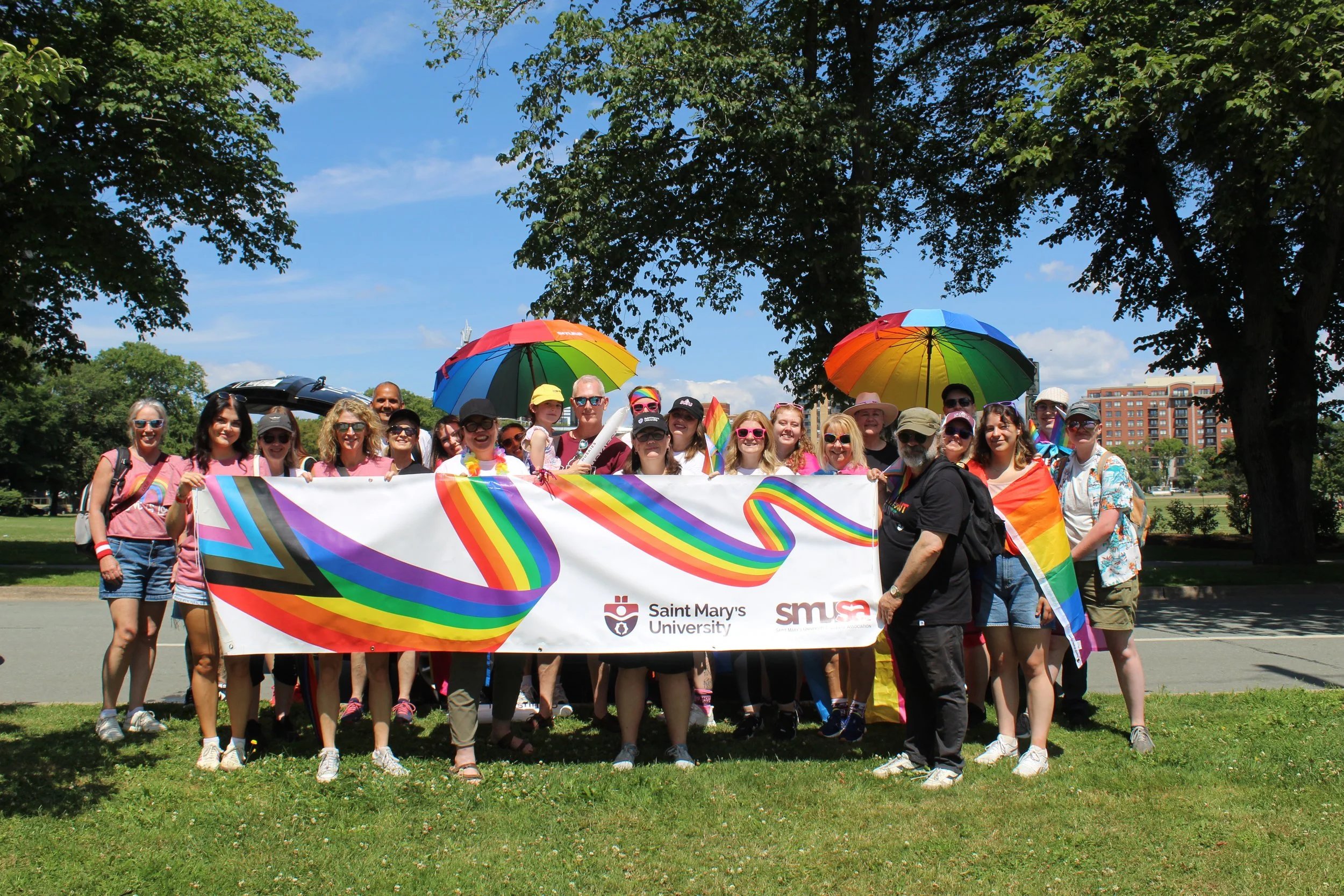 A group of people hold a SMU and SMUSA pride banner