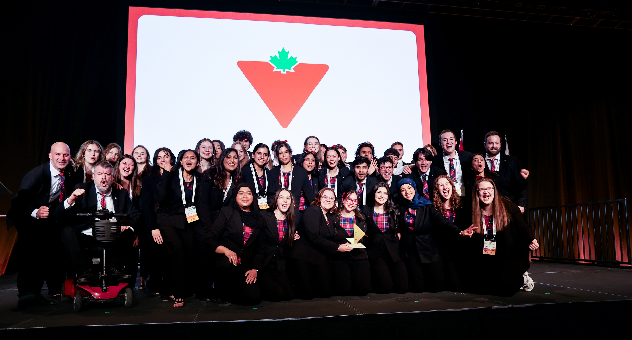 A large group of students on stage, smiling.