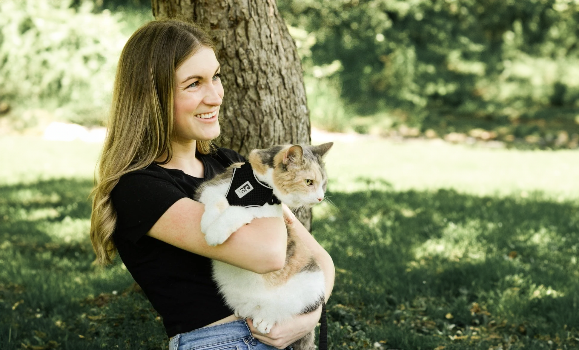 Angela holds a cat outdoors