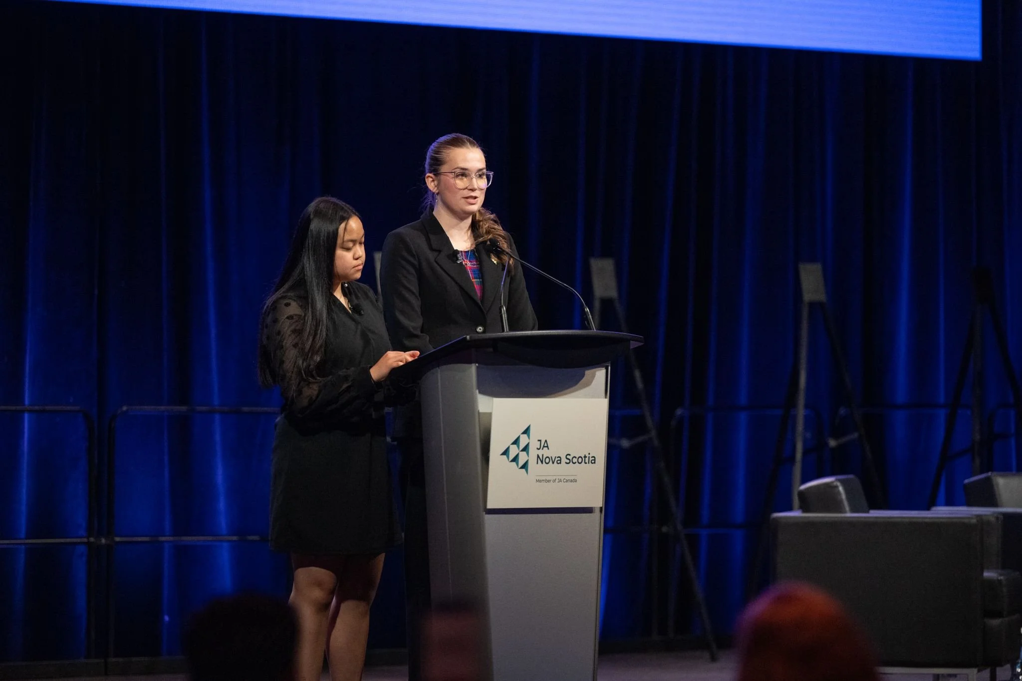 Emma stands behind a podium
