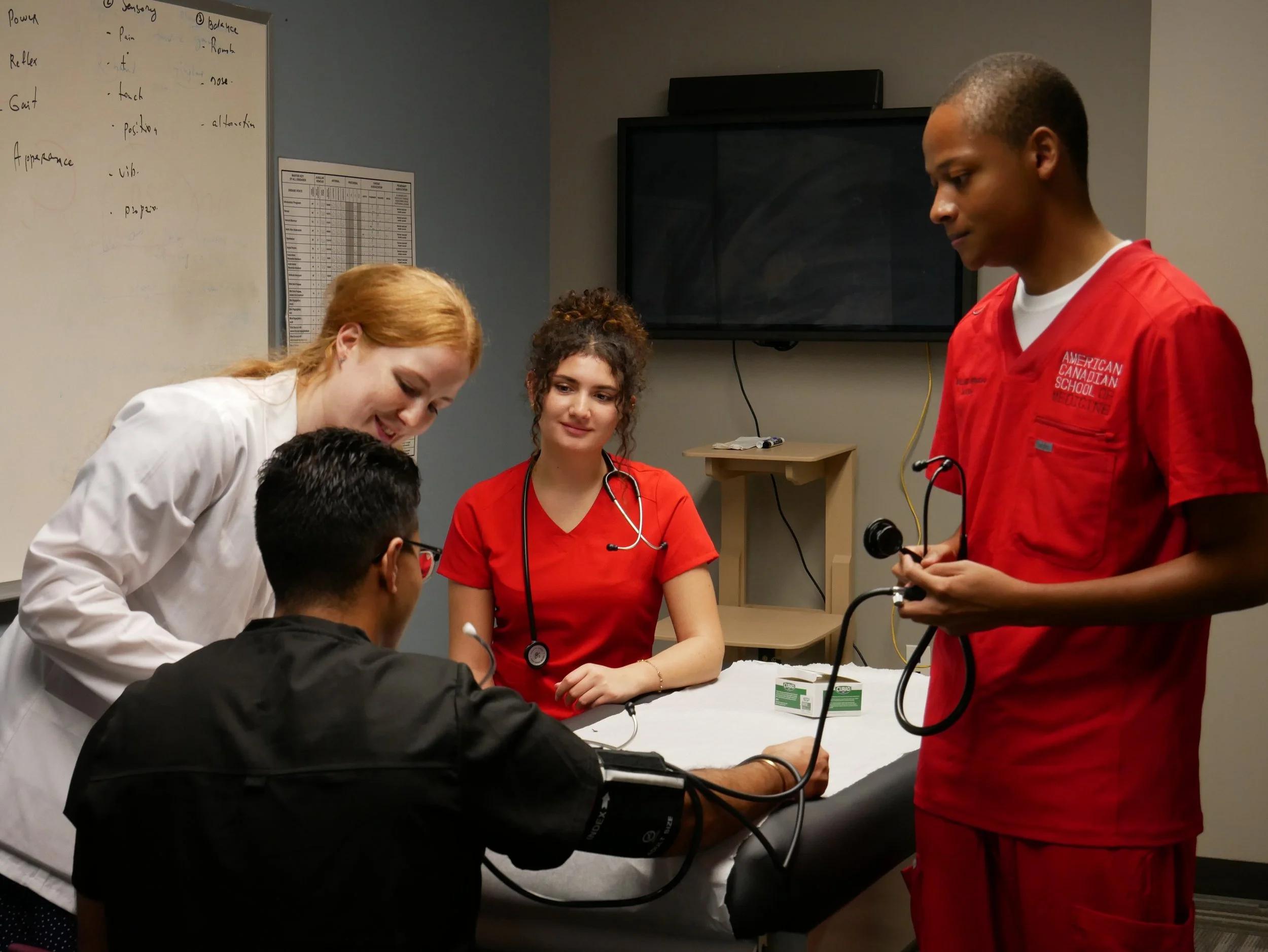 Medical students in scrubs practice in a clinic
